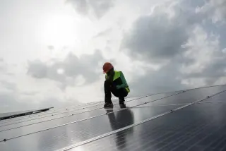 Personne inspectant un panneau solaire pour assurer un entretien optimal